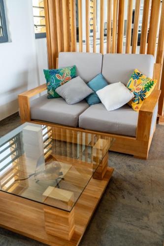 a living room with a couch and a glass coffee table at Calypso Bay in Bouillante