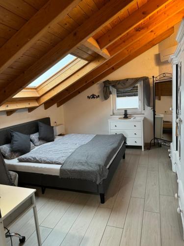 Dielheim的住宿－Spacy 3 Bedroom plus Sleeping couch Apartment Work&Travel close to Heidelberg，一间带一张床的卧室,位于带木制天花板的房间内