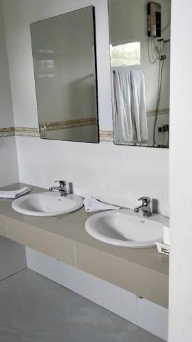 a bathroom with two sinks and a large mirror at AHI Maldives in Omadhoo