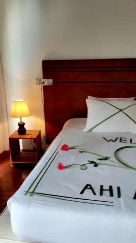 una camera da letto con un letto con fiori rossi di AHI Maldives a Omadhoo