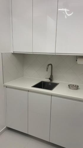 - une cuisine blanche avec un évier et des placards blancs dans l'établissement Un studio de luxe Les Champs Elysées, à Paris