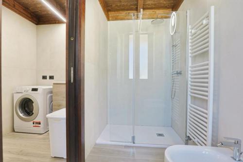 y baño con ducha y lavadora. en villa dei cento Pini en Monteroni di Lecce