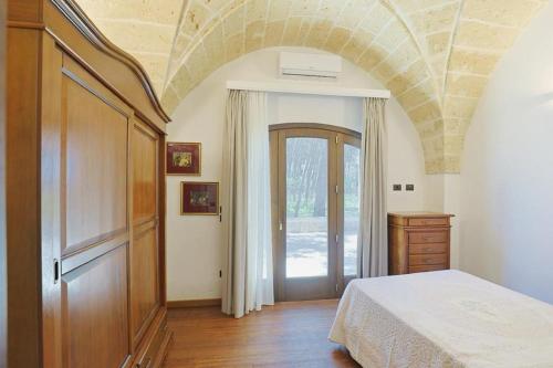 una camera con un letto, un comò e una porta di villa dei cento Pini a Monteroni di Lecce