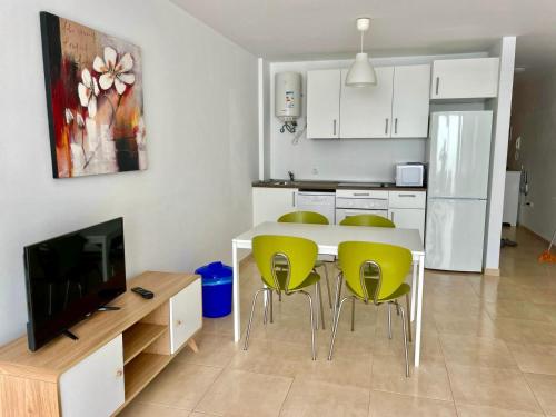 a kitchen with a table and chairs and a television at Casa Mate Cotillo Mar in Cotillo