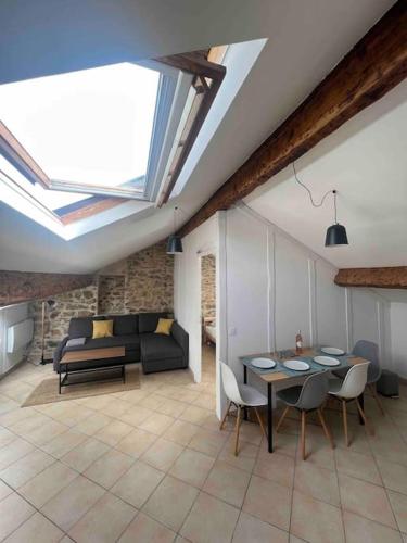 - un salon avec des lucarnes, une table et des chaises dans l'établissement Sous les toits de Golfe Juan, 2 à 4 personnes, à Vallauris