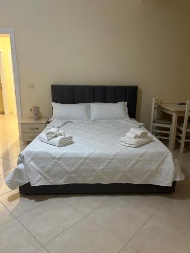 a bedroom with a bed with two towels on it at Rest House in Vlorë