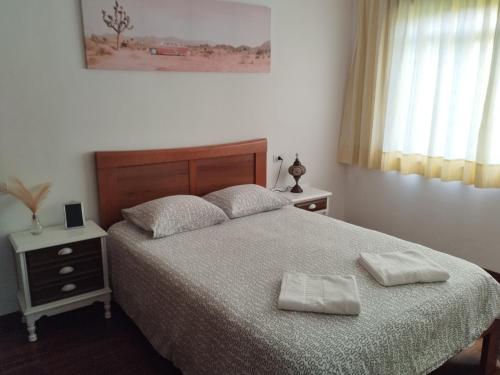 a bedroom with a bed with two towels on it at Villa Rica House in Negreira
