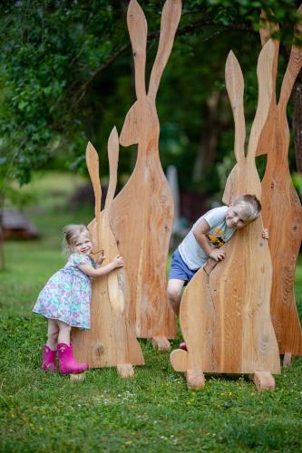 two little girls playing in wooden bunnies at Folwark Wierzchy in Wierzchy
