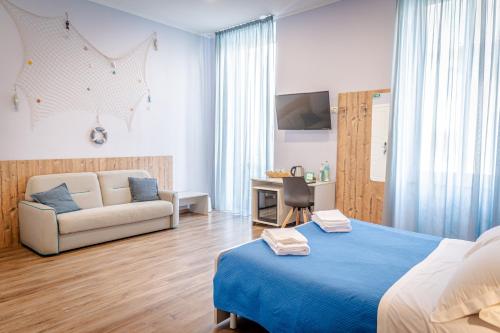 een slaapkamer met een blauw bed en een bank bij i sapori del levante in La Spezia