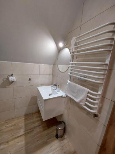 a white bathroom with a sink and a mirror at Agroturystyka Bliżej Natury in Rymanów-Zdrój