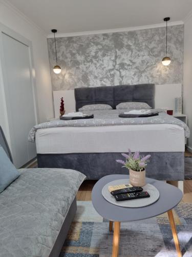 una camera con un grande letto e un tavolo con un tavolino sidro di Apartments Deni a Mostar