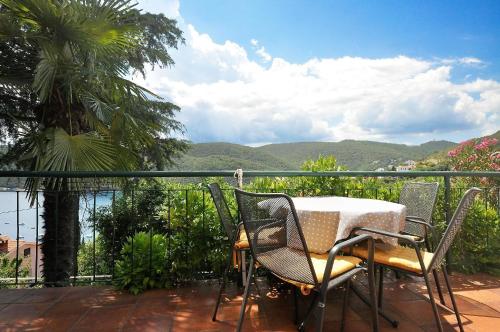 a table and chairs on a balcony with a view of the mountains at Ferienwohnung für 4 Personen ca 45 qm in Rabac, Istrien Bucht von Rabac in Rabac