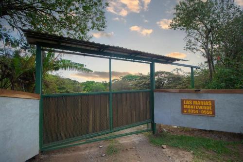 una puerta con un cartel delante de una valla en Las Marias Mountain View Cottages, en Monteverde