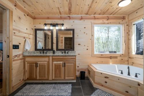 Cabaña de madera con baño con bañera y espejo en Sunset Ridge, en Ranger