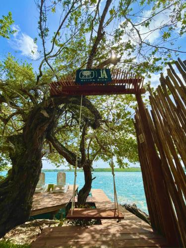 a wooden dock with a sign hanging from a tree at Estancia del Agua Luxury View in Xul-Ha