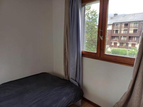 a bed in a room with a window at Appartement PISCINE in Bourg-Saint-Maurice