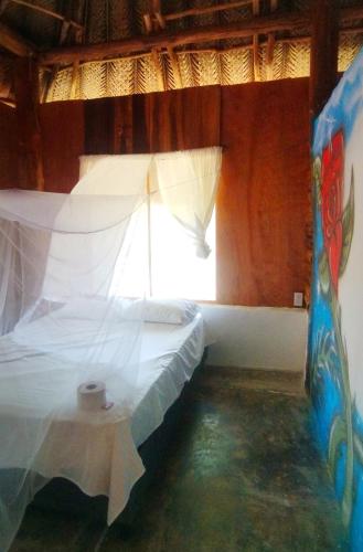 a bedroom with a bed in a room with a window at Zirumake Hostel Dentro del Parque Tayrona in El Zaino