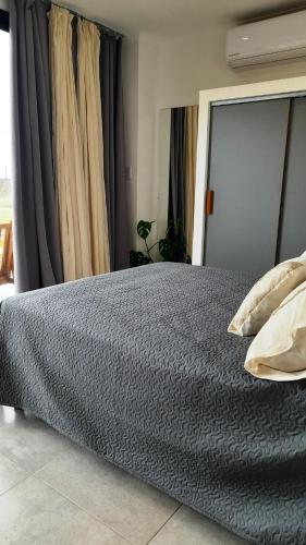 1 dormitorio con 1 cama con edredón gris en Belize Apart en San José