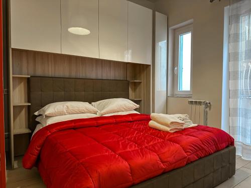 a bedroom with a red bed with pillows on it at Il Palazzetto in Gaeta