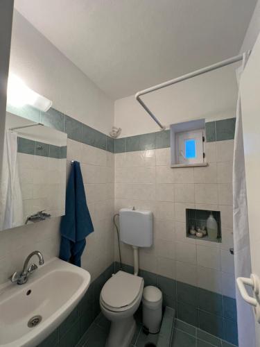 bagno con servizi igienici bianchi e lavandino di J&D Apartment a Kóstos