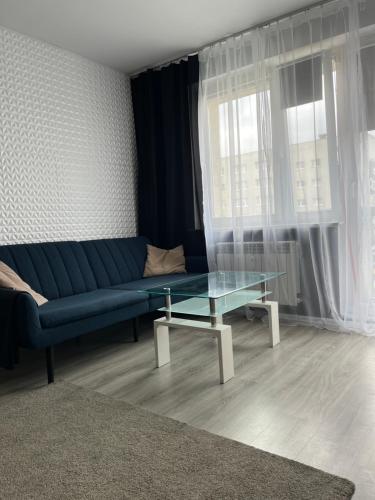 sala de estar con sofá azul y mesa de cristal en 4 kąty na granicy z Sopotem en Gdansk