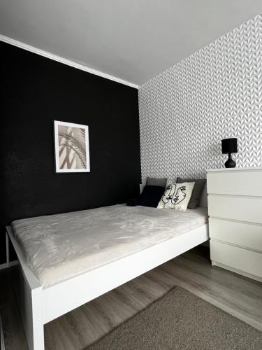 1 dormitorio con cama blanca y pared negra en 4 kąty na granicy z Sopotem en Gdansk