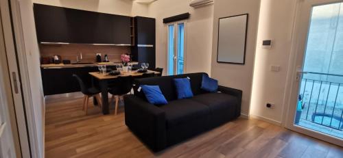 a living room with a black couch and a table at Orelli House in Lissone