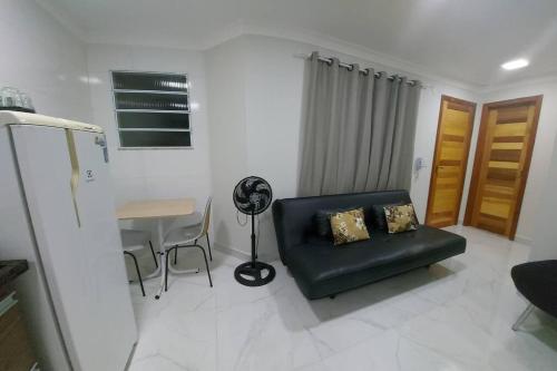 ein Wohnzimmer mit einem schwarzen Sofa und einem Schreibtisch in der Unterkunft Apartamento Ponta da Fruta para até 4 pessoas 201 in Vila Velha