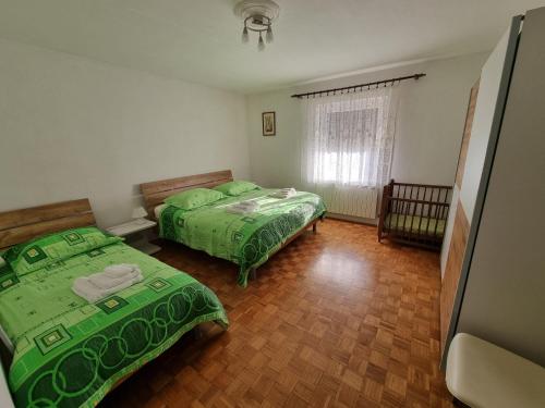 1 dormitorio con 2 camas y ventana en Pri Stari murvi, en Vogrsko