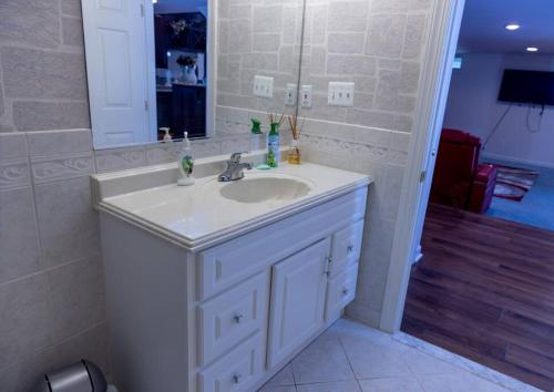 a bathroom with a white sink and a mirror at Luxurious Private Basement Suite in Ashton in Silver Spring