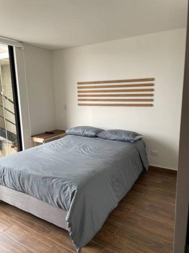 ein Schlafzimmer mit einem großen Bett mit blauer Bettwäsche in der Unterkunft Apartaestudio Verum LV - Modelia in Bogotá