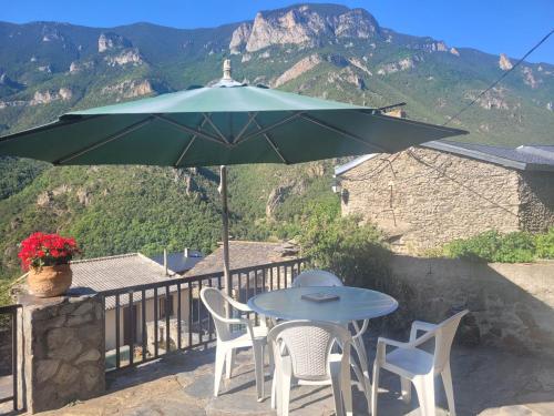 d'une table, de chaises et d'un parasol sur le balcon. dans l'établissement Gite Bellevue avec cheminée et bois offert, à Nohèdes