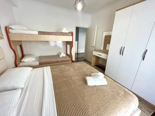 a bedroom with two bunk beds with towels at Fishta Quality Apartments Q5 31 in Velipojë