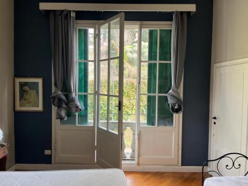 um quarto com uma porta, uma janela e uma cama em Albero Mago em Florença