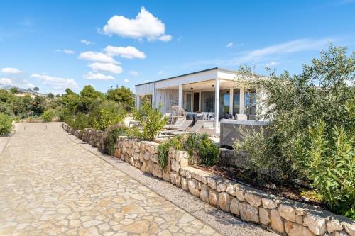 a home with a stone retaining wall and a stone driveway at Ferienhaus mit Privatpool für 4 Personen ca 54 qm in Drage, Dalmatien Norddalmatien in Drage