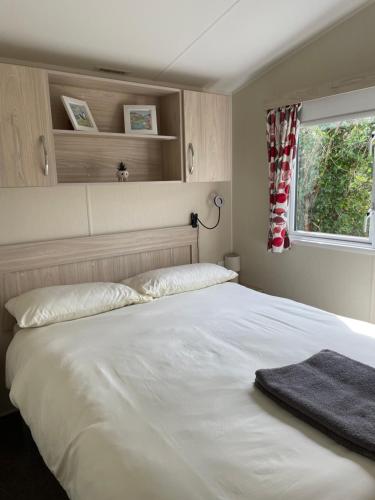 a bedroom with a large white bed with a window at Olivia Ann in Caernarfon