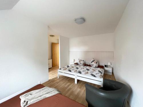 een slaapkamer met een bed en een zwarte stoel bij Vintage-Wohnung mit Wintergarten in Tauche