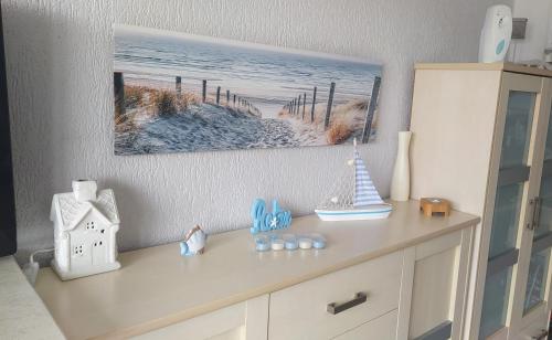 a dresser with a painting on the wall and a shelf at Apartament SUNNY in Gdynia