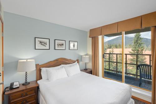 a bedroom with a bed and a large window at Cascade Lodge in Whistler