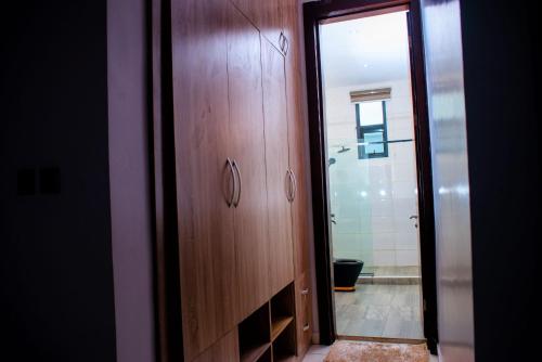uma casa de banho com um armário de madeira e um espelho em 4 Bedroom Terraced Duplex for Airbnb Short Stay in Ikeja em Ikeja
