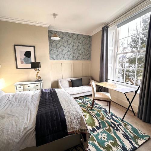 a bedroom with a bed and a table and a couch at Hillside in Bristol