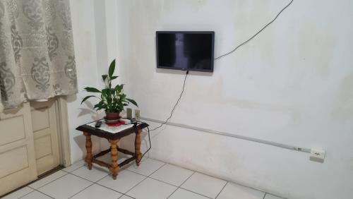 a room with a table with a tv on a wall at Bela vista Rio in Porto Alegre