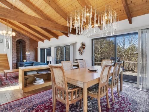 a dining room with a table and chairs and a chandelier at Stylistic Home and Easy Walk to the Beach in Truro