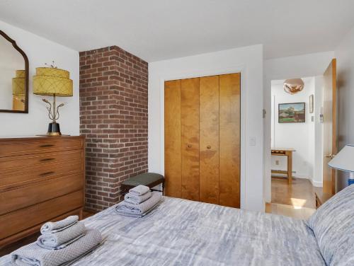 a bedroom with a bed and a brick wall at Stylistic Home and Easy Walk to the Beach in Truro