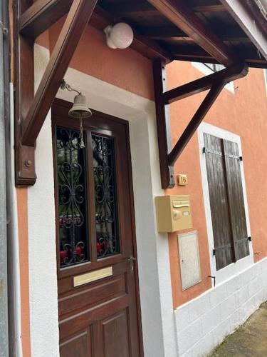 a building with a wooden door and a window at le Gîte de Marie Ray Sur Saône in Ray-sur-Saône