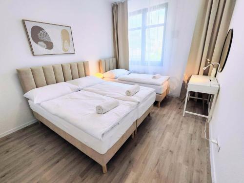 a bedroom with two beds and a table in it at Cinnamon - free private parking - old town - air conditioning in Bratislava