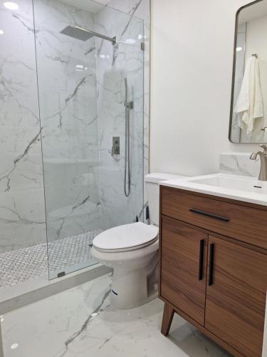 a bathroom with a shower and a toilet and a sink at Casa Del Sol in Lauderhill