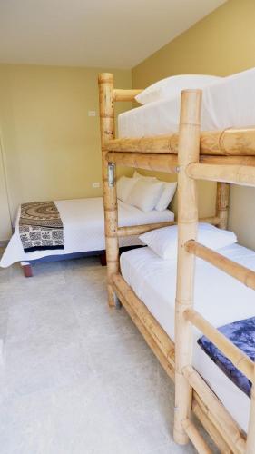 a room with two bunk beds in a house at Paradise Project Hostal in Montañita