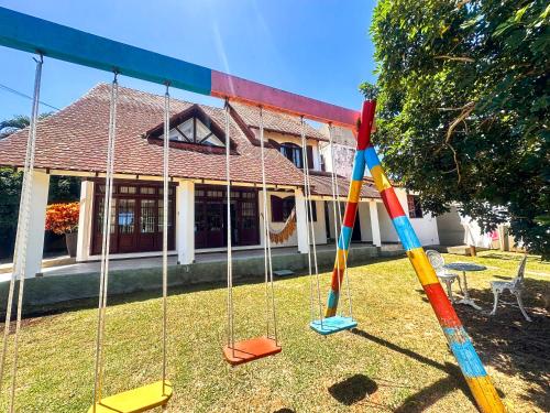 a swing set in front of a house at Casa na Praia dos Ingleses para até 12 pessoas in Florianópolis