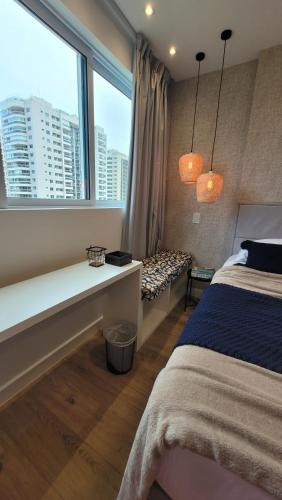 um quarto com uma cama e uma grande janela em Suíte Casal, RioCentro Parque Olímpico Barra da Tijuca no Rio de Janeiro